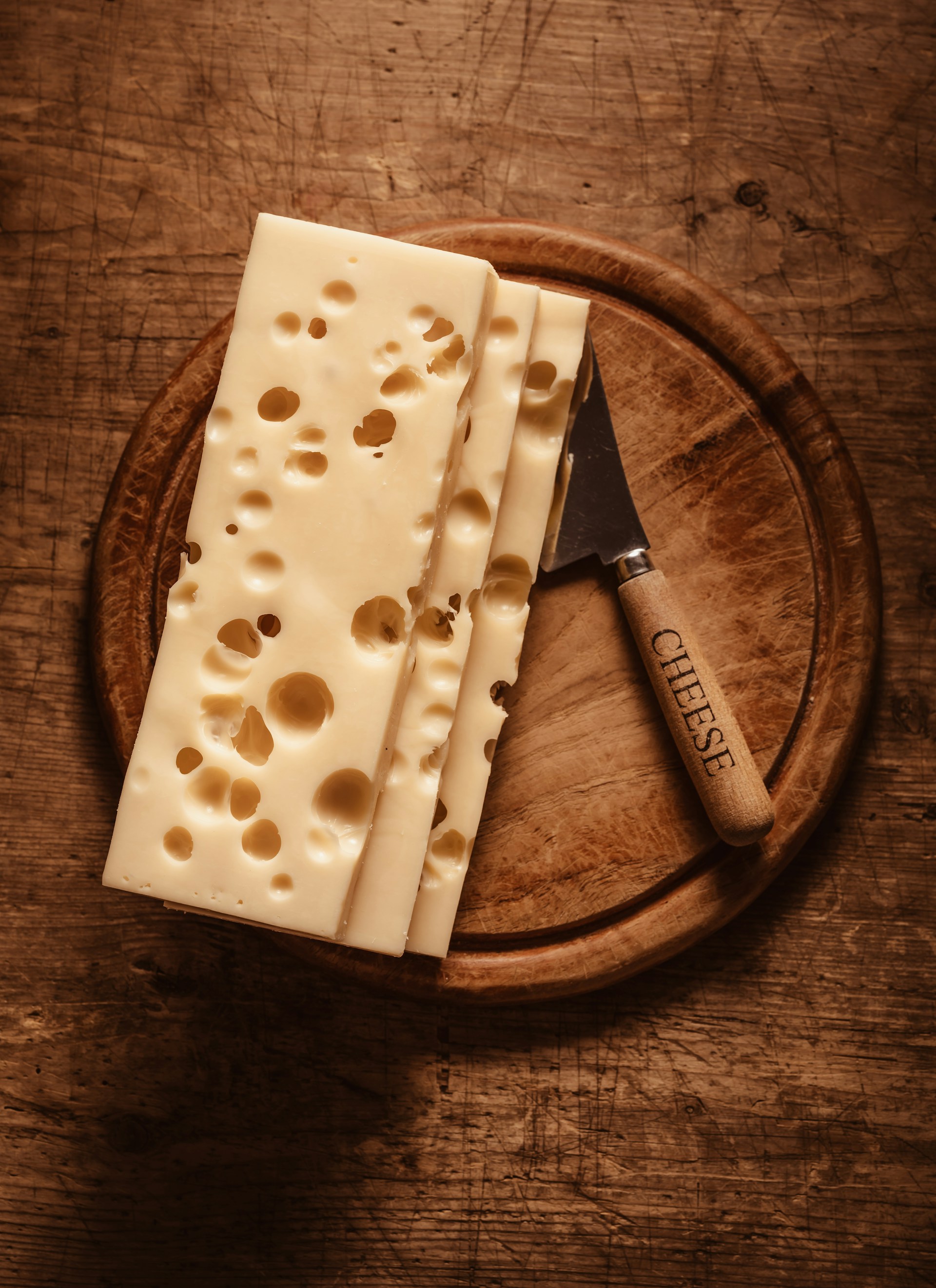 Sliced artisanal cheese on a wooden board